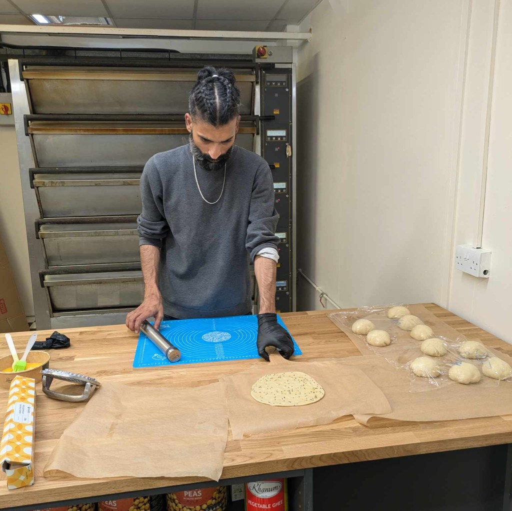 Faiq is in the cafe preparing dough to make more kulcha naan.